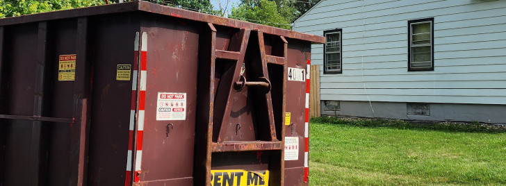 Residential dumpster on the street near house